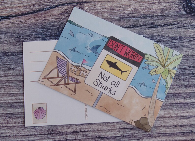 May include: A postcard with a beach scene featuring a palm tree, a beach chair, and a sign that reads "Don't Worry, Not all Sharks". The sign is yellow with a black shark silhouette. The postcard is watercolor style with a blue ocean and sandy beach.
