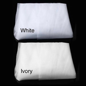 May include: Two pieces of white tulle fabric, one labeled "White" and the other labeled "Ivory".
