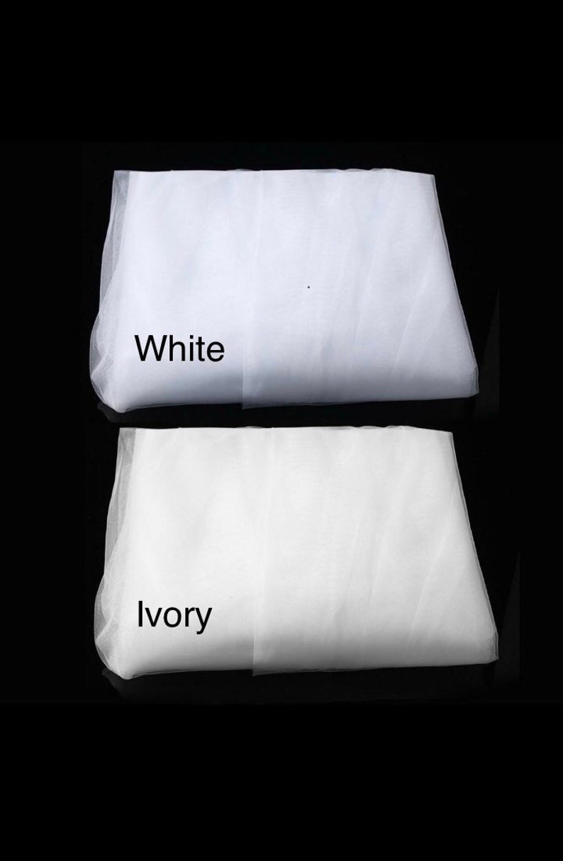 May include: Two pieces of white tulle fabric, one labeled "White" and the other labeled "Ivory".