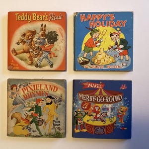 May include: Four vintage children's books with colourful covers. Titles include "Teddy Bear's Picnic," "Happy's Holiday," "Pixieland Rhymes," and "The Magic Merry-Go-Round." Each book is a "Pixie Book" with illustrations of animals and children.