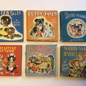May include: A collection of six vintage children's books with illustrated covers. Titles include "Kitten Tales," "Puppy Tales," and "The Kittie-Poosies." The books feature illustrations of kittens, puppies, ladybirds, and woodland creatures. Each book is a "Pixie Book."