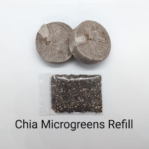 May include: A close-up of a package containing chia microgreens refill. The package includes two brown, round, compressed soil discs and a small bag of black chia seeds.