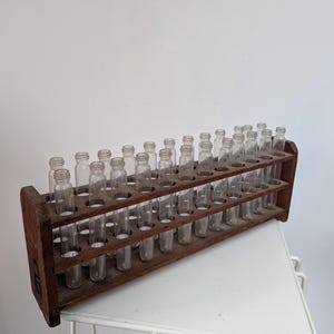 Tubos de vidrio de laboratorio antiguos con base de madera de los años 60/70.