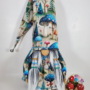 ¡Gnomos de hongos! Nariz de fieltro suave cosida a mano con piercings de plata. Lleva un collar plateado con el símbolo de la paz o el sol. ¡Viene con una cesta de hongos!