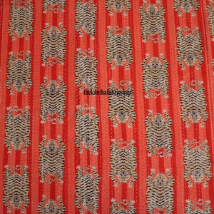 May include: Red fabric with a repeating pattern of black and white tiger stripes. The tigers are facing upwards and are arranged in vertical rows.