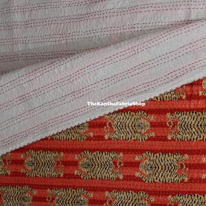May include: A red and white striped kantha quilt with a tiger print design. The quilt is folded in half, showing the white side with red stitching. The text "TheKanthaFabricShop" is visible on the white side.