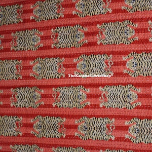 May include: Red and white striped fabric with a repeating pattern of black and white tigers. The fabric has a quilted texture and the text "The Kantha Fabric Shop" is visible in the center of the image.