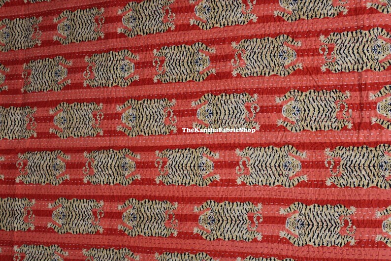 May include: Red and white striped fabric with a repeating pattern of black and white tigers. The fabric has a quilted texture and the text "The Kantha Fabric Shop" is visible in the center of the image.