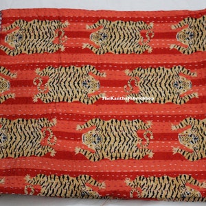 May include: Red and brown kantha quilt with a repeating pattern of tigers. The quilt is made of cotton and has a hand-stitched design. The text "TheKanthaFabricShop" is visible in the lower center of the quilt.