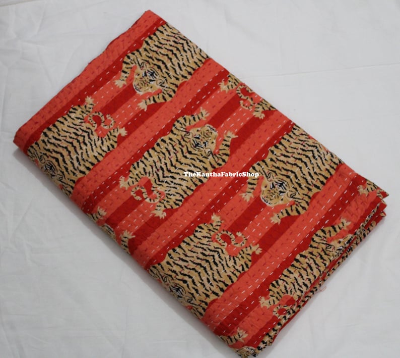 May include: Red and black striped fabric with a repeating pattern of tigers. The fabric is folded in half and has a subtle texture.