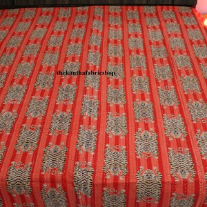 May include: Red and white striped kantha quilt with a repeating pattern of tigers. The quilt has a hand-stitched design and is made of cotton. The text "thekanthafabricshop" is printed in the center of the quilt.