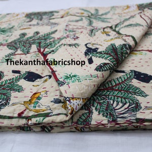 Könnte beinhalten: Eine beige Kantha-Steppdecke mit einem Dschungel-Druck mit Tukanen, Zebras, Leoparden und Palmen. Die Steppdecke ist in der Hälfte gefaltet und hat ein handgenähtes Design.