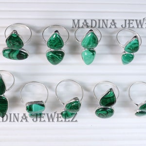 Pu&ograve; includere: Otto anelli d'argento con pietre di malachite verde. Gli anelli presentano due pietre ciascuno, una pi&ugrave; grande dell'altra. Le pietre sono di un verde intenso con un motivo marmoreo. Gli anelli sono disposti in due file di quattro. Il testo "MADINA JEWELZ" &egrave; visibile nella parte superiore dell'immagine.