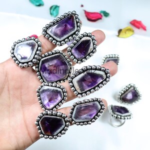 以下が含まれることがあります： 銀のセッティングにアメジストの宝石がセットされたリングのコレクション。リングは、さまざまなアメジストの形状とサイズを特徴とし、すべてが美しいパープルカラーです。