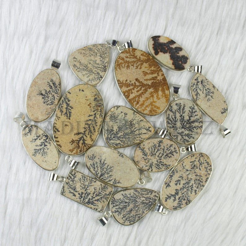 May include: A collection of 12 dendritic agate pendants with silver bail settings. The pendants are various shapes and sizes, with a natural brown and black dendritic pattern.