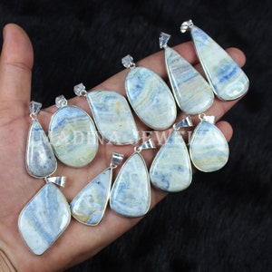 May include: A collection of 11 blue and white gemstone pendants with silver settings. The pendants are various shapes and sizes, and are all set in a silver bail.