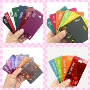 May include: A set of 16 plastic cards in various colours, including red, blue, green, yellow, orange, purple, and black. The cards are labelled with the colour name and are arranged in a fan shape. The cards are translucent and have a glossy finish.