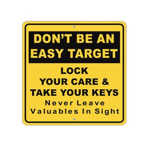 May include: Yellow warning sign with black text that reads "Don't Be An Easy Target Lock Your Care & Take Your Keys Never Leave Valuables In Sight".
