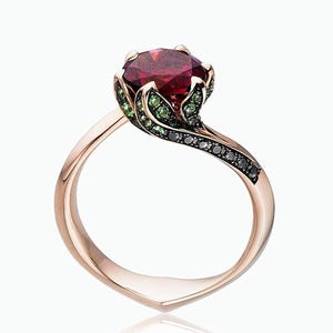 May include: A rose gold ring featuring a red gemstone surrounded by green gemstones. The band is twisted and set with black diamonds.