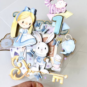 Shown here is an Alice in Wonderland-inspired cake decoration, mounted on a clear acrylic circle with the characters drawn in watercolor. Made with high quality materials