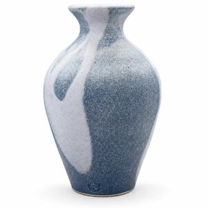 May include: A ceramic vase with a tapered neck and a rounded body, featuring a mottled blue and white speckled glaze pattern. The surface has a textured appearance with a distinct white swirl design against a deep blue background and a small stamp.