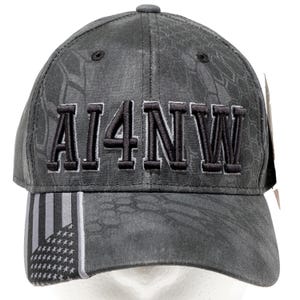 May include: Gray baseball cap with the text "AI4NW" embroidered in black. The cap features a camouflage pattern and a design of the American flag on the side. A stylish accessory for outdoor activities.