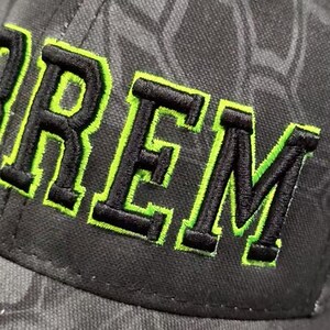 Ham radio embroidered callsign hat with 3d stitching and neon green outline. Up close stitching detail.