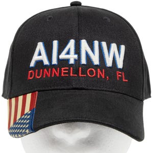 May include: Black baseball cap with the text "AI4NW DUNNELLON, FL" in white and red embroidery. The cap features an American flag design on the side.