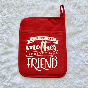May include: Red quilted pot holder with white text that reads "First my mother forever my friend".