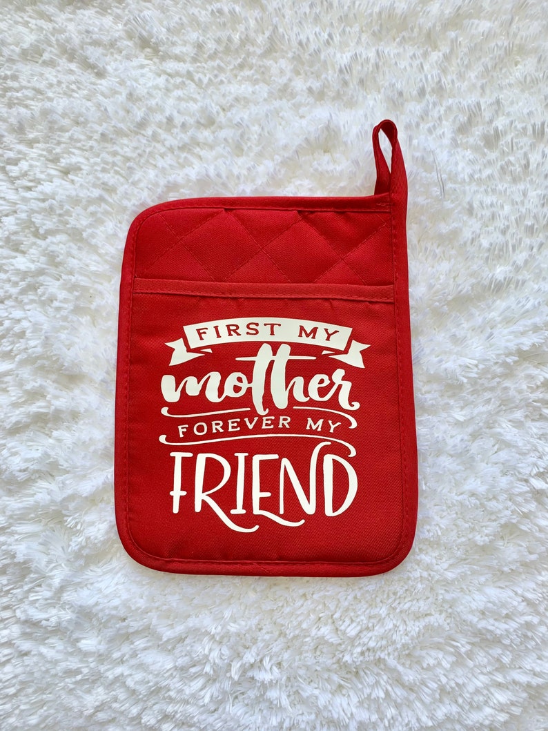 May include: Red quilted pot holder with white text that reads "First my mother forever my friend".