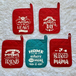 May include: Set of six red and teal pot holders with white text. The text on the pot holders reads: "A mother is the heart of a home", "Happy Mother's Day", "First my mother forever my friend", "Home is where your mom is", and "Blessed mama".
