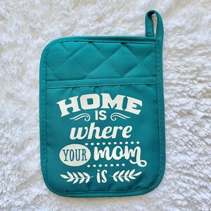 May include: Teal quilted pot holder with the text "Home is where your mom is" in white.