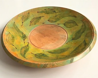 Plato de madera de arce torneada a mano, teñida y tallada con hojas, firmado por el artista.