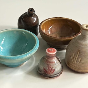 Wiele miniaturowych misek i wazonów ceramicznych wykonanych w pracowni, sygnowanych przez artystkę Carolyn Wickes