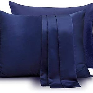 May include: Two blue satin pillowcases with a smooth, silky texture. The pillowcases are folded and stacked on top of each other.