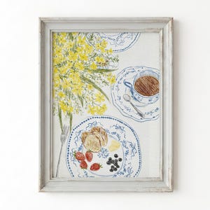 May include: A framed watercolor illustration featuring a bouquet of yellow flowers, a cup of brown tea on a blue and white patterned saucer with a spoon, and a plate with bread, strawberries, and blueberries, all set on a white surface.