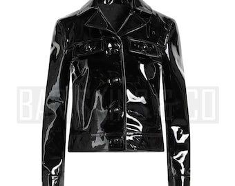 May include: A glossy black jacket with a classic collar, two chest pockets, and button closures. The jacket has a shiny, patent leather-like finish, reflecting light. The sleeves are long, and the overall design is tailored.