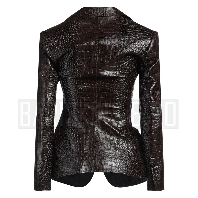 May include: A dark brown blazer with a textured, crocodile-skin pattern. The tailored jacket features a notched lapel, long sleeves, and button details. The back view of the blazer is shown, highlighting the structured design and fit.