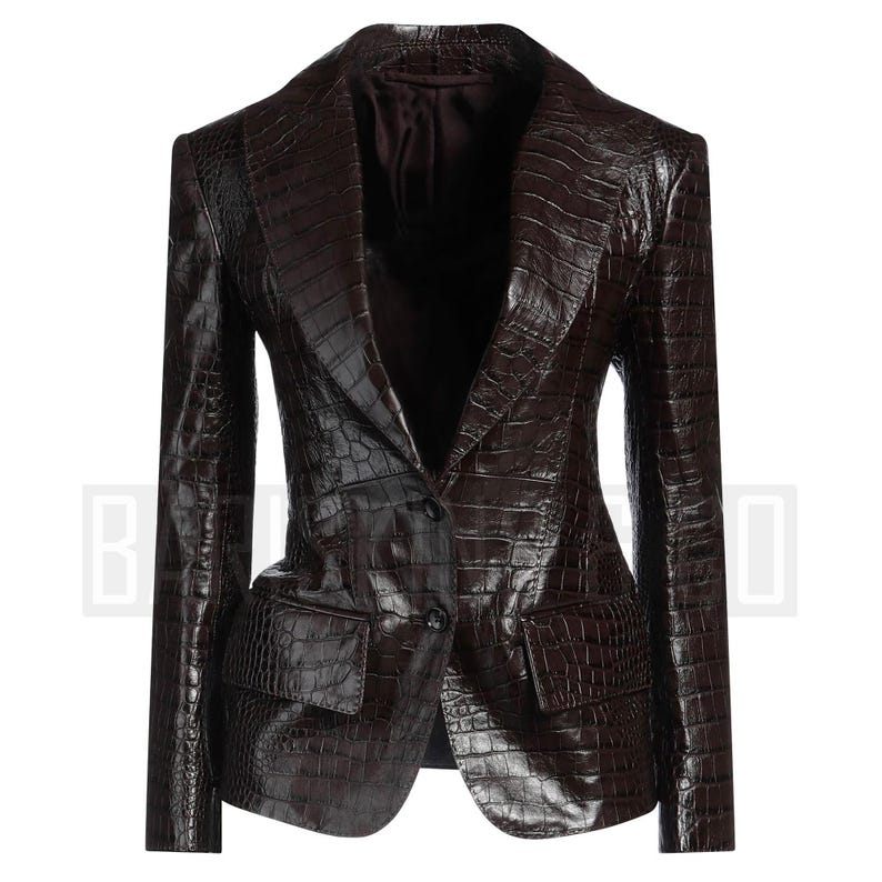 May include: A dark brown blazer with a crocodile skin texture. The blazer has a notched lapel, two front pockets, and a single-button closure. The jacket is tailored with a fitted silhouette.