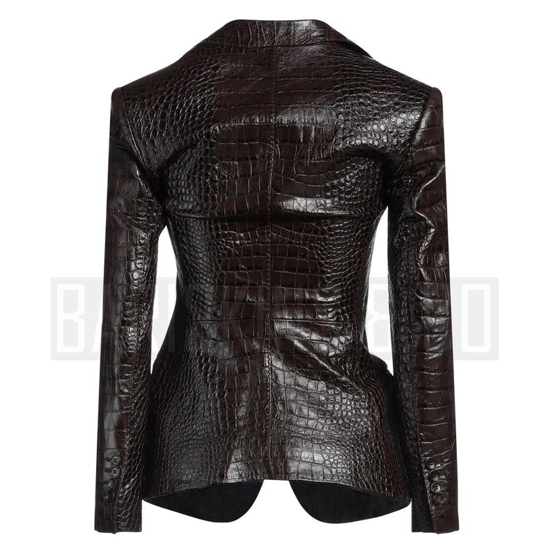 May include: A dark brown blazer with a crocodile skin texture. The blazer has a notched lapel, long sleeves, and a two-button closure. The back of the blazer is visible, showcasing the tailored fit and textured pattern.