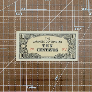 May include: A vintage Japanese government ten centavo banknote with a black and white design. The note features the text "THE JAPANESE GOVERNMENT TEN CENTAVOS" in black lettering. The note is in good condition and has a light yellow background.