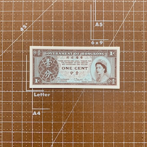 May include: A vintage Hong Kong one cent banknote. The note features text in English and Chinese, with a portrait of a woman on the right. The note is primarily brown and white.