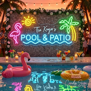 Könnte beinhalten: Ein individuelles Neonschild an einer Steinmauer mit einem rosa Flamingo, einer gelben Sonne und einer grünen Palme. Der Text lautet The Kroger's POOL & PATIO in blauem Neonlicht. Das Schild ist mit weißen Rosen verziert und hängt über einem Pool.