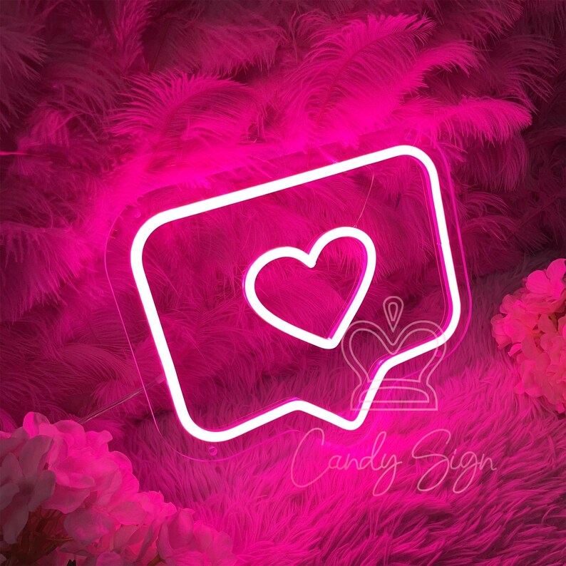 May include: Pink neon sign shaped like a speech bubble with a white heart inside. The sign says "Candy Sign" at the bottom.