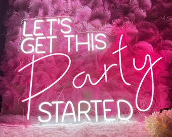 May include: A white neon sign with the text LET'S GET THIS Party STARTED mounted on a wall covered in pink feathers. The sign features a combination of block and cursive lettering, emitting a bright glow against the textured pink background.