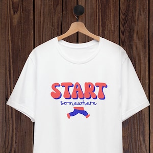 Könnte beinhalten: Ein weißes Kurzarm-T-Shirt mit dem Schriftzug START in großen roten Buchstaben mit blauen Umrandungen, gefolgt von dem Wort somewhere in blauer Schreibschrift und einer Grafik eines laufenden Beinpaars in blauer Hose und roten Schuhen.