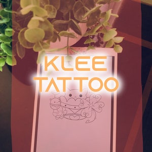 Puede incluir: Un dibujo digital de un personaje de gato de dibujos animados con un corazón y nubes sobre un fondo rosa. El texto "KLEE TATTOO" está escrito en naranja sobre el dibujo.