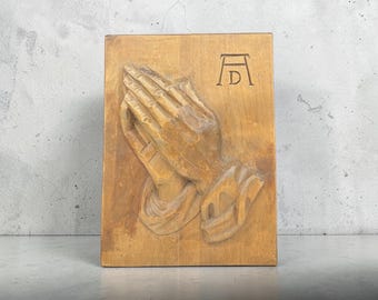 Placa de madera con relieve de manos orando de Durero, talla alemana de 1970, obra de Alfred Zwink.