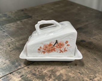 Mantequera de porcelana vintage con diseño floral y tapa, estilo rústico campestre.