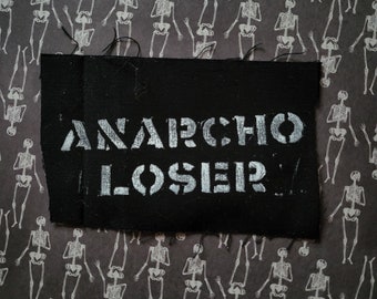 May include: Black fabric patch with white stencil lettering that reads "ANARCHO LOSER".